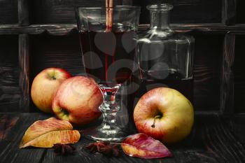 Warming autumn cocktail sangria with apple in glass wine glass.Dark key