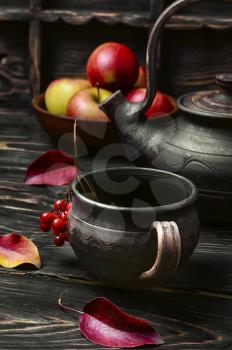 clay kettle with tea and the autumn harvest autumn apples