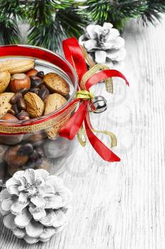 Glass Christmas jar with hazelnuts,almonds and nuts.Copy space