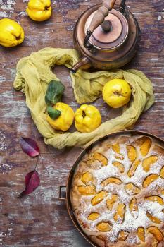 aromatic tea in hand and pie with autumn quince