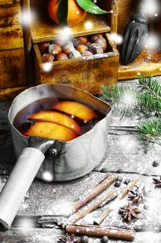 Hot red wine with oranges and cupboard with spices