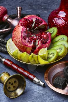 Eastern smoking hookah and dish with kiwi,pomegranate and lime