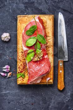 Raw veal meat on kitchen board with spice