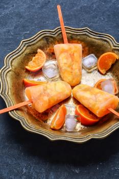 Tasty ice cream with tangerines in copper dish