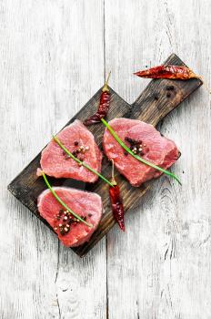 raw chops veal steak with peppers and spices