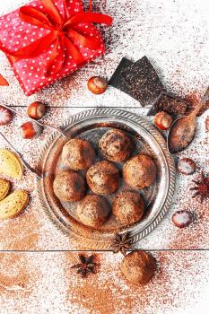 Chocolate truffles with cocoa and nuts and red box with gift