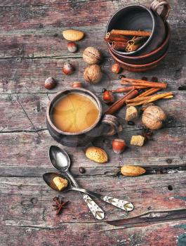 mug of coffee,almonds,cinnamon and nuts on rustic background