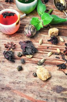 various types of fragrant herbal tea on vintage wooden background