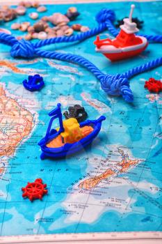 Symbolic toy ship on a topographic map of the world