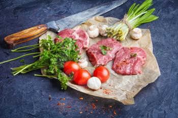 Sliced raw veal steaks with ramson and tomatoes