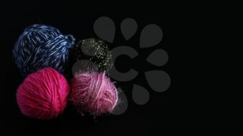 Four skeins of knitting yarn isolated on black background