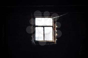 Old wooden window in dark. Sunlight outside, darkness inside