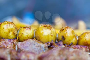Potatoes cook on meat barbecue. Shish kebab cook. Tasty grill dinner cooking. Food BBQ background. Roasted fresh beef meat