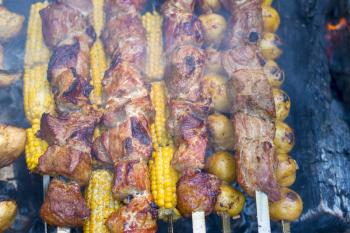 Barbecue shish kebab cook. Tasty grill corn and potatoes dinner cooking. Food BBQ background. Roasted fresh beef meat