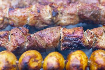 Barbecue shish kebab cook. Tasty grill potatoes dinner cooking. Food BBQ background. Roasted fresh beef meat