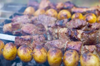 Barbecue shish kebab cook. Grill potatoes dinner cooking. Tasty food BBQ background. Roasted fresh beef meat