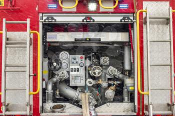 Fire truck equipment inside back vehicle. Open back side of red firetruck with water supply connection