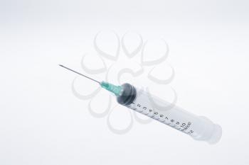 Plastic syringe on a soft gradient background, studio shot, high depth of feild