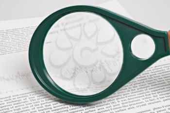 Magnifier on article with the schedule, high depth of field, studio shot