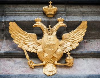 Golden double eagle on stone wall. Coat of arms of Russian federation