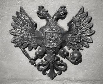 Double Eagle - Emblem of Russia. Ancient black bas-relief on gray vintage wall