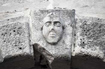 Bas-relief of a man's face on ancient house facade in Perast town, Montenegro
