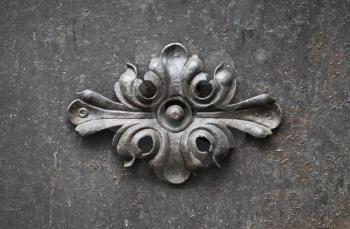 Ancient forged floral decoration element on black door