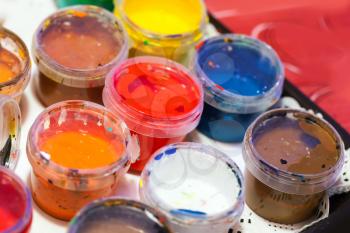 Colorful acrylic paints in small plastic cans