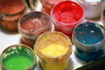 Colorful acrylic paints in small plastic cans. Macro photo