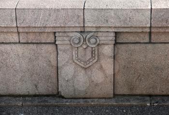 Granite border of an old bridge with fun skull face looked design element