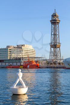 BARCELONA, SPAIN - AUGUST 27, 2014: vista port view with Montjuic cable car tower and white sculpture on the buoy