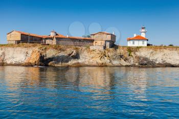 Lighthouse and old wooden buildings on St. Anastasia Island. Black Sea, Bulgaria