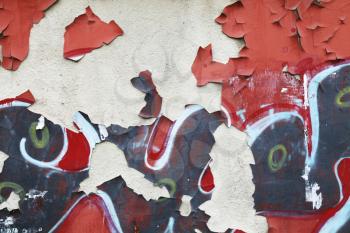 Abstract grungy wall background texture with damaged paint layer and graffiti fragments