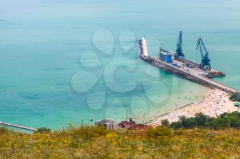 Cargo port terminal with cranes on pier. Balchik resort town on the coast of Black Sea, Bulgaria
