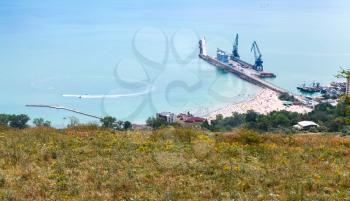 Cargo port terminal with cranes on pier. Balchik resort town, coast of Black Sea, Bulgaria