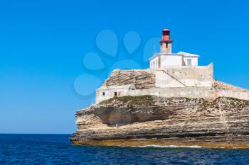 Madonetta lighthouse, red tower and white building. Entrance to Bonifacio port, Corsica island, France