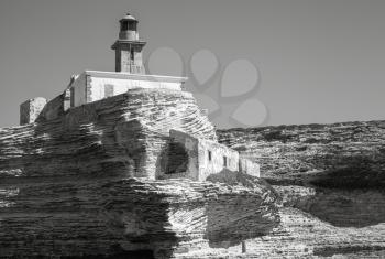 Monochrome photo of Madonetta lighthouse. Entrance to Bonifacio port, Corsica island, France