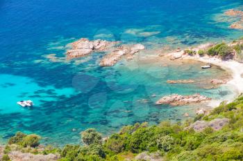 Corsica island, Cupabia gulf. Coastal landscape with small motor boat near wild rocky beach