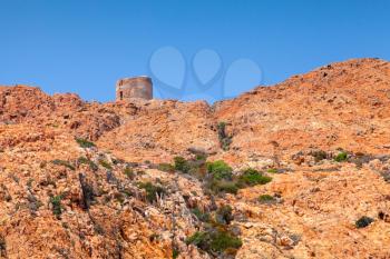 Old Genoese tower on Capo Rosso cliff, Corsica, France. Piana region