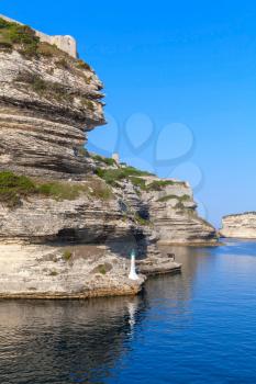 Cliff with white lighthouse lantern, entrance to the port of Bonifacio, Corsica island, France
