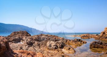 Coastal rocks in the Mediterranean sea water. South Corsica natural landscape, France. Plage De Capo Di Feno