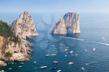Faraglioni rocks of Capri island, Italy. Mediterranean Sea coastal landscape with yachts and pleasure boats