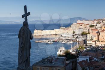 Silhouette of Jesus Christ statue with cross as a part of Saint Francesco Cathedral exterior and historic quarter of Gaeta town, Italy