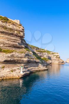 Rocky cliff with white lighthouse lantern in the entrance of Bonifacio port, Corsica island, France