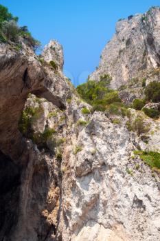Vertical coastal landscape with rocks and cave. Capri island, Mediterranean Sea coast, Italy