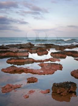 Bright red stones on the coast of Mediterranean Sea. Turkler, Alanya, Turkey