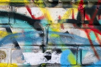 An abstract colorful paint graffiti fragment on the gray urban brick wall