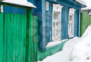 Winter street with wooden old rural houses and snow drifts. Historical town Kolomna, Moscow region, Russia