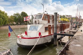 Old white ship stands moored, Seine river coast in Paris, France