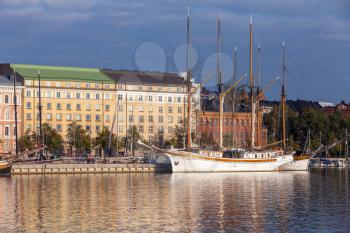 HELSINKI, FINLAND - SEPTEMBER 14, 2014: quay of Helsinki with moored old sailing ships and classical buildings facades in the morning light